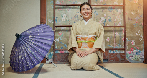 Kimono, portrait and umbrella with Japanese woman on floor of Okiya for traditional culture or fashion. Heritage, kneeling and smile of confident asian person in outfit for hospitality or service photo