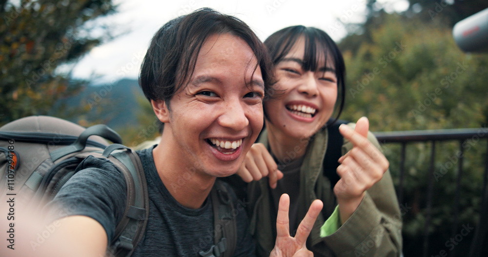 Fototapeta premium Peace sign, selfie and smile with couple in nature for holiday, travel or vacation on mountains of Japan. Adventure, hiking and photograph with Japanese people outdoor on Mount Takao for memory