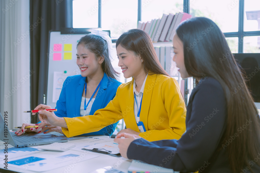 Group of Asian businesswomen discuss charts and graphs showing successful teamwork, graphing company growth goals, presentations on computer screens. Group of Asian businesswomen discuss charts and graphs showing successful teamwork, graphing company growth goals, presentations on computer screens.