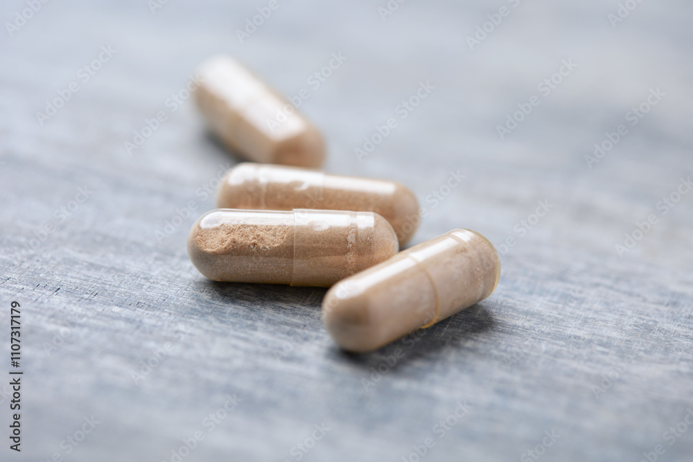 Reishi capsules. Concept for a healthy dietary supplementation. Wooden background. Soft focus. Close up. Reishi capsules. Concept for a healthy dietary supplementation. Wooden background. Soft focus. Close up.