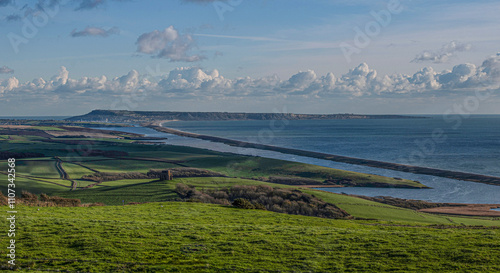 Chesil Beach in Dorset U.K  looking towards Portland with St Cathrerin's  chapel Abbotsbury in  the forground. photo