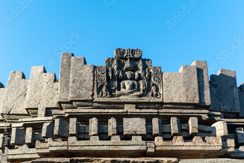 Faded carving of an ancient Jain monk figure on the walls of an old temple. photo