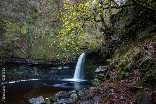 Long exposure image of Sgwd Gwladys; Lady Falls, waterfalls, surrounded by autumn leaves 