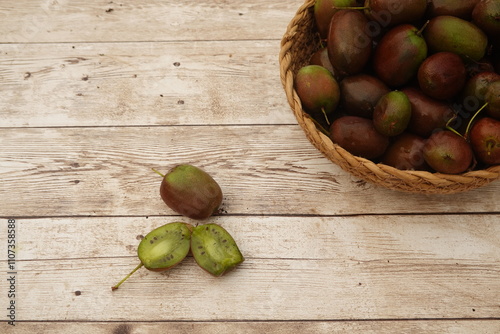 Fresh hardy kiwis showing their vibrant green inside on rustic wooden table photo