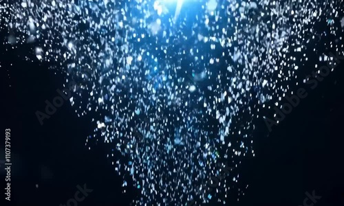 A shower of blue and silver confetti rolled out, sparkling like tiny stars, with the background being dark black, creating a magical night sky effect photo