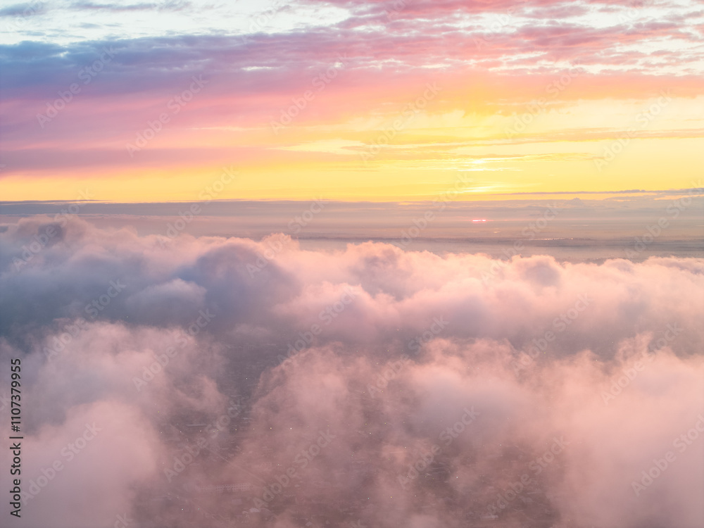 Naklejka premium Drone view of clouds at sunset. Beautiful clouds covered the city. Bright evening golden, pink and blue landscape.
