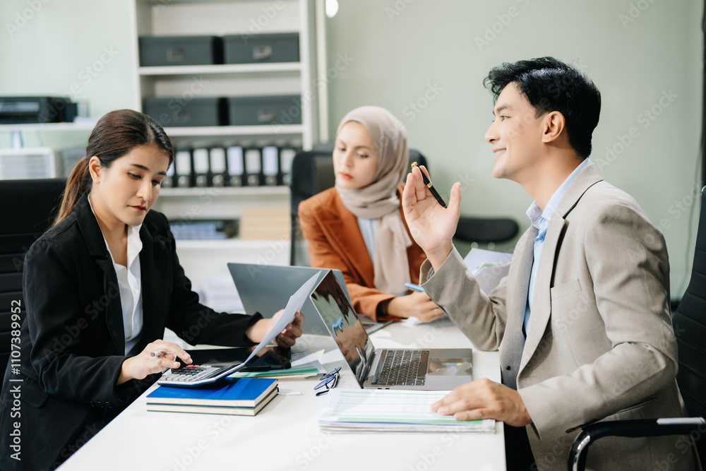 Fototapeta premium Asian businesspeople while collaborating on a new project. using a laptop and tablet