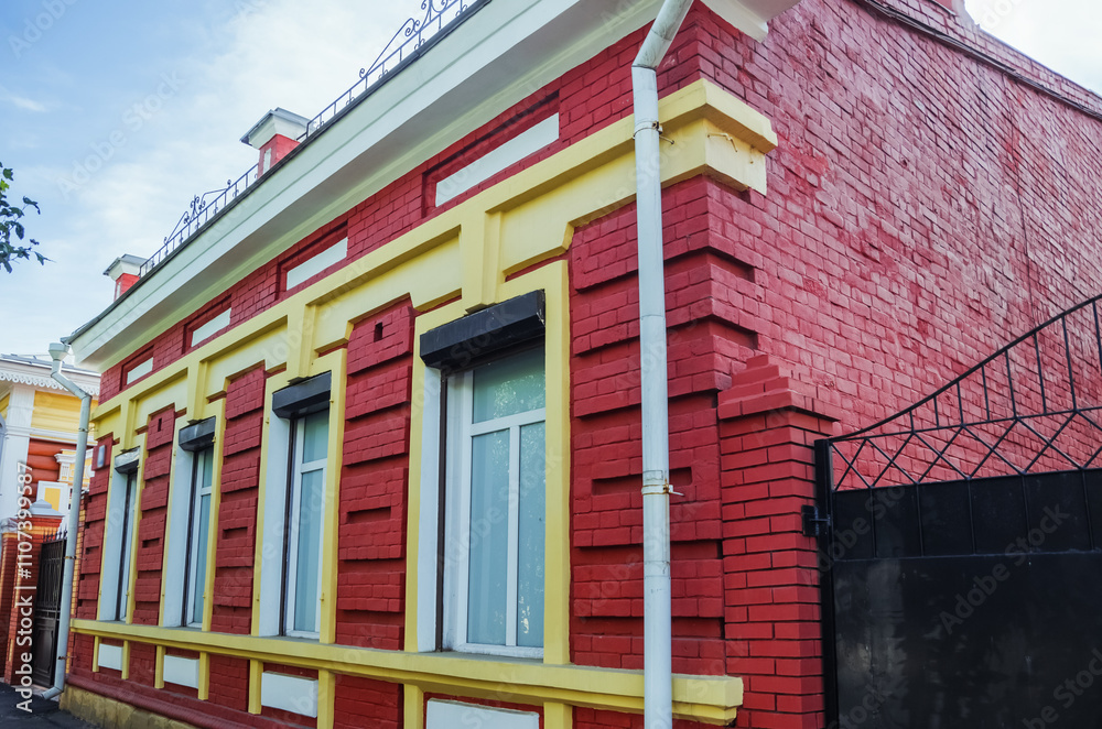 Obraz premium Beautiful brick facade of a building in Irkutsk, showcasing architectural style amidst autumn colors.