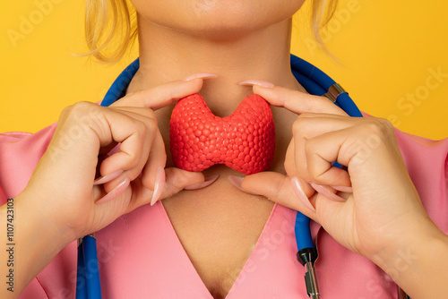 Female doctor is holding anatomical model thyroid gland. Help and care concept