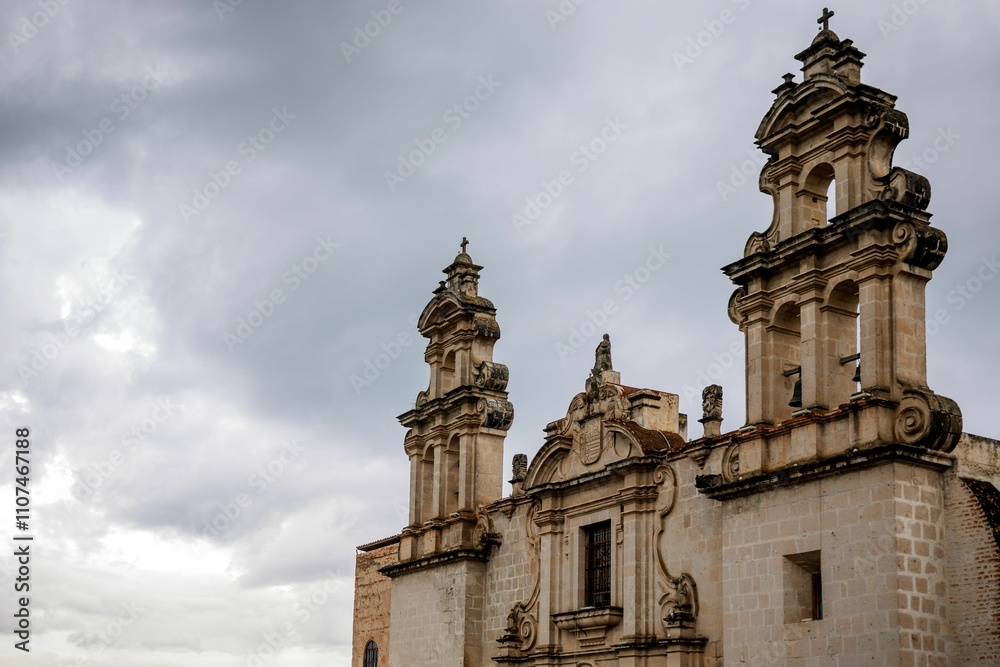 Fototapeta premium Historic stone church facade under a cloudy sky.