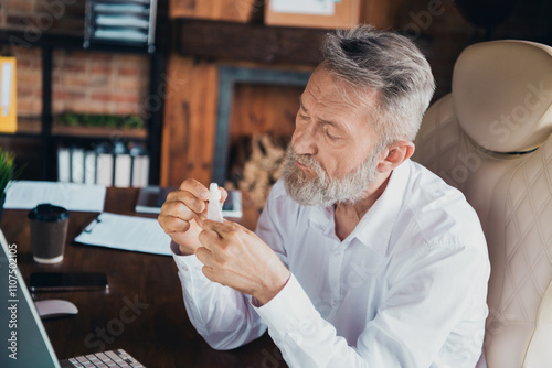 Photo of handsome mature mister use nasal drops dressed white shirt formalwear comfortable startup office loft room interior photo