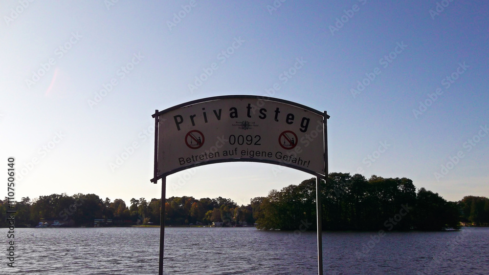 Steg am See mit Schild und Aufschrift - Privatsteg - Betreten auf eingene Gefahr