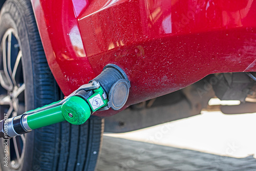 filling up a red car with LPG at a universal gas station. Economic crisis. rising oil and fuel prices