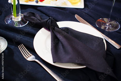 Festive banquet table setting with classic white dishes and dark textiles. Festive dinner decor. photo