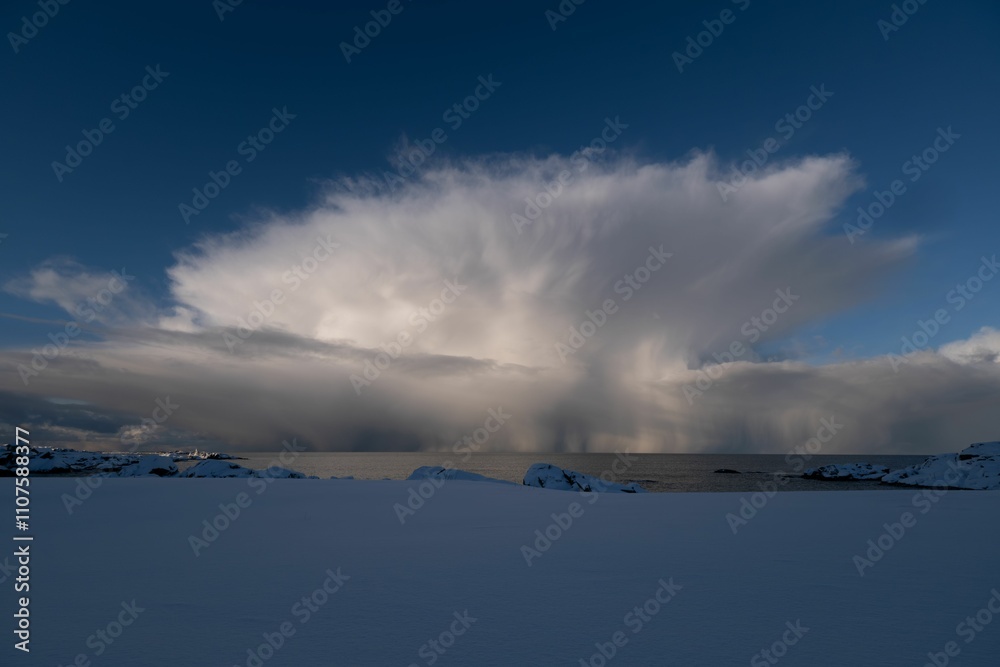 Obraz premium Dramatic Cloud Formation Over Snowy Landscape