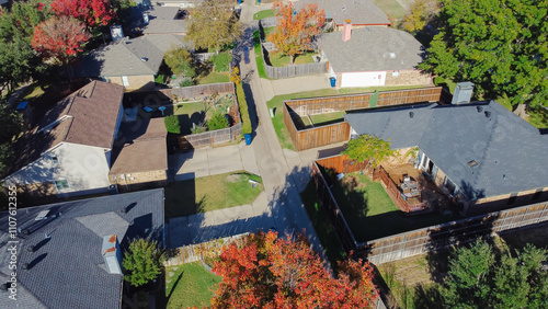 Wooden fence backyard with swimming pool in upscale suburban residential neighborhood colorful fall foliage autumn leaves in Coppell, suburbs Dallas, Texas, fast growing housing market, aerial photo