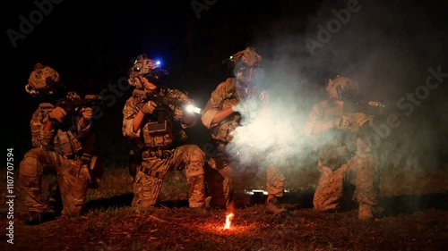 Soldiers in camouflage uniforms aiming with their rifles ready to fire during Military Operation at night