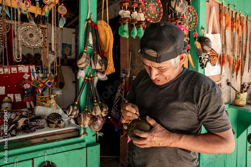 Peruvian jungle artisan working on his products to sell them in his market stall.