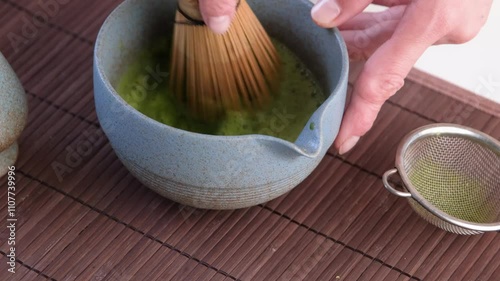 Step by step tutorial making Japanese matcha tea. Step four, whisking tea until froth
