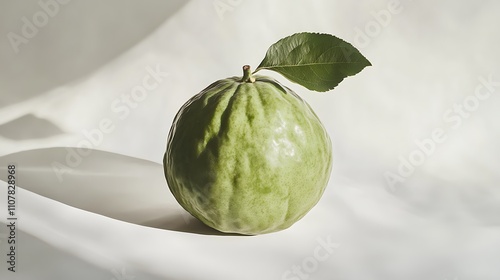 A fresh custard apple with a deep green skin, placed in the center of a white background with soft shadows photo