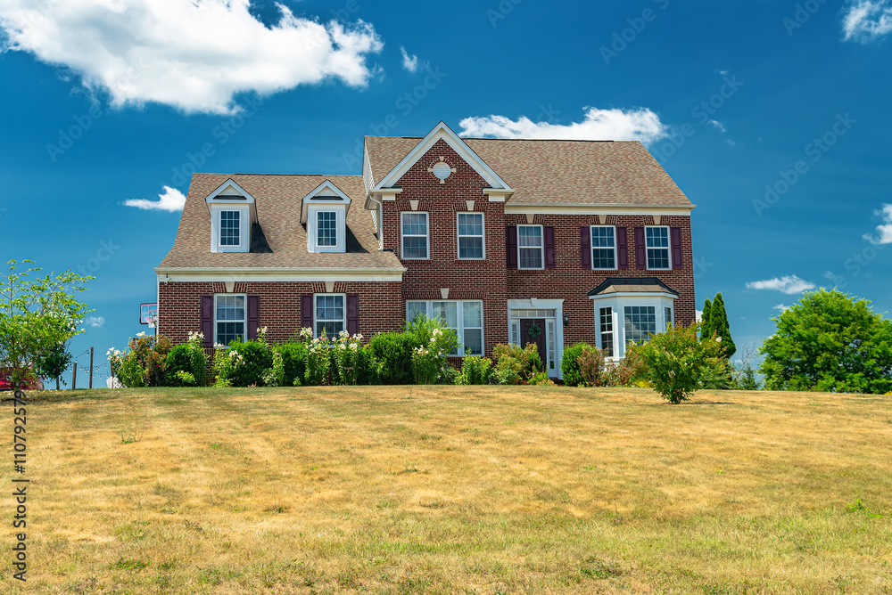 Modern farmhouse home exterior with brick walls sunny autumn day under white clouds and blue sky. Modern farmhouse home exterior with brick walls sunny autumn day under white clouds and blue sky.