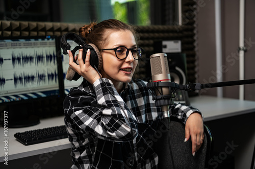 Portrait of a radio host working live in a radio studio with a microphone and headphones. photo