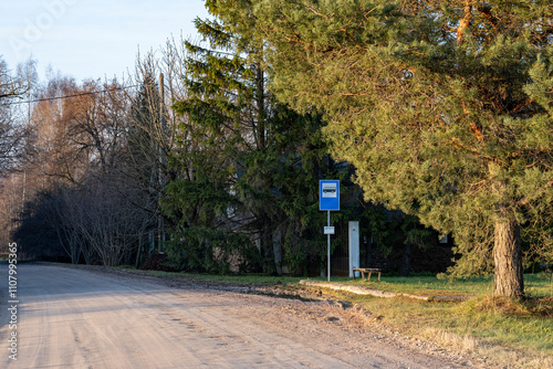 Fototapeta Naklejka Na Ścianę i Meble -  bus stop with sign in Latvia countryside on gravel road, trees on road sides