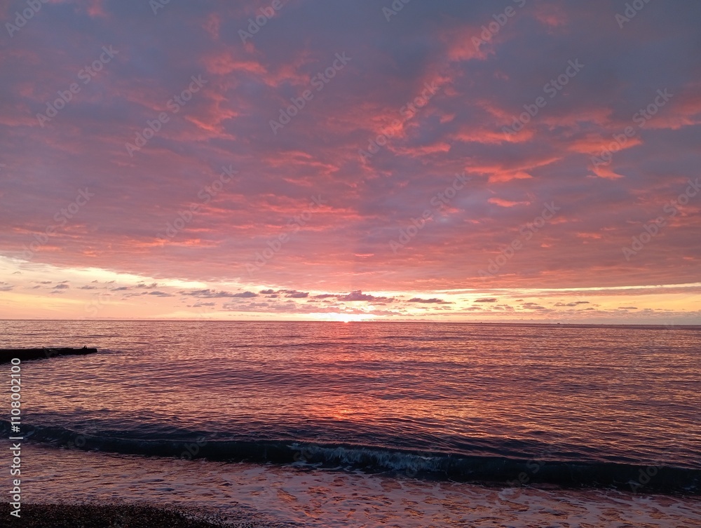 Obraz premium sunset on the beach. Red sunset on the sea. The sun is setting over the sea horizon