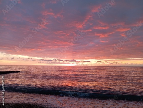 sunset on the beach. Red sunset on the sea. The sun is setting over the sea horizon
