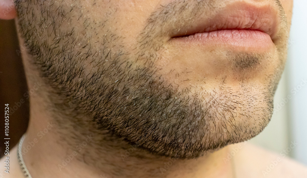 Fototapeta premium Close-up of a man's facial hair and lips, showcasing the texture and detail of his beard. Perfect for grooming or personal care themes.