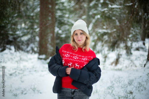 happy middle-aged caucasian woman in red pullover with deers in snowy winter forest. christmas weeken concept photo