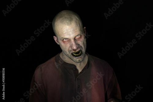 Bloody male zombie in darkness 