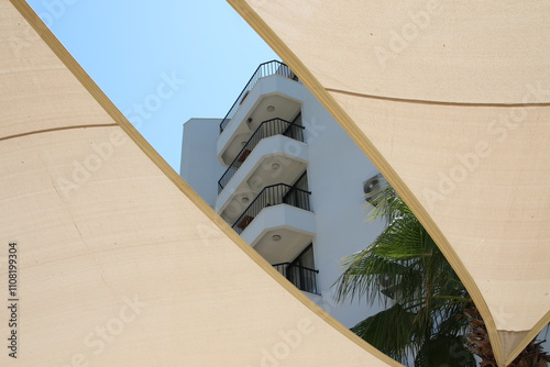 Obraz na płótnie Summer vibes: A modern building with a shade sail providing shade and shelter from the sun w salonie
