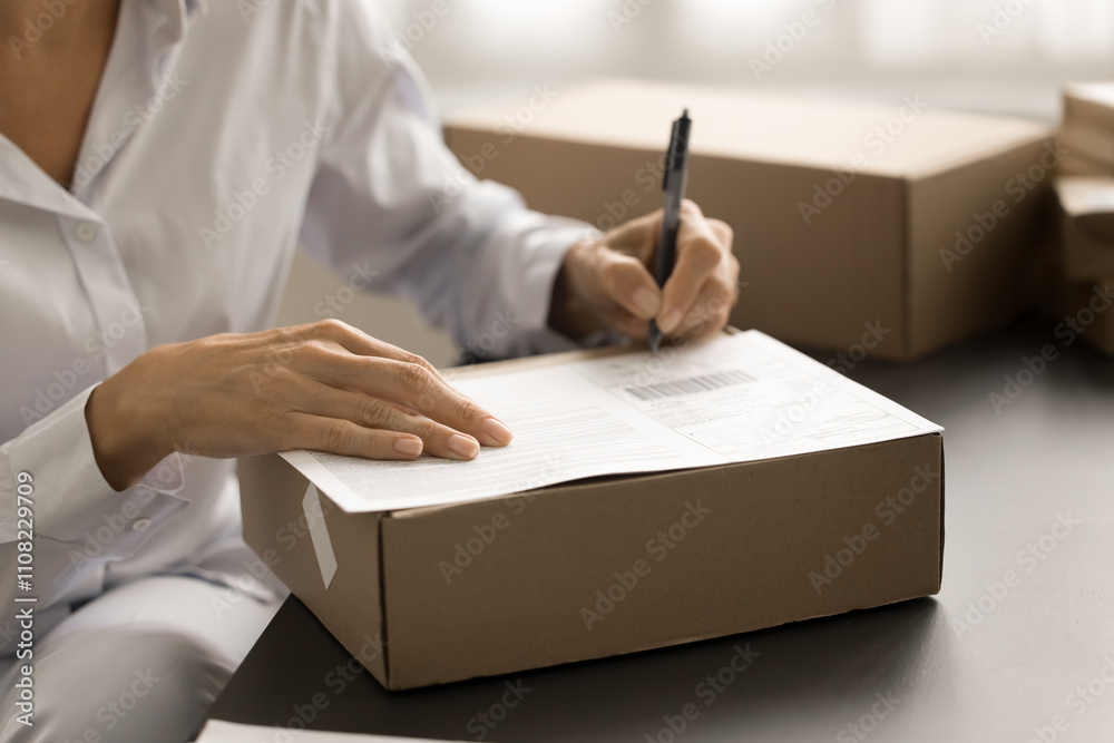 © fizkes - Post office manager woman preparing delivery document, writing notes on paper cardboard box for transportation, sending parcel, package, purchase to Internet store customer © fizkes - Post office manager woman preparing delivery document, writing notes on paper cardboard box for transportation, sending parcel, package, purchase to Internet store customer