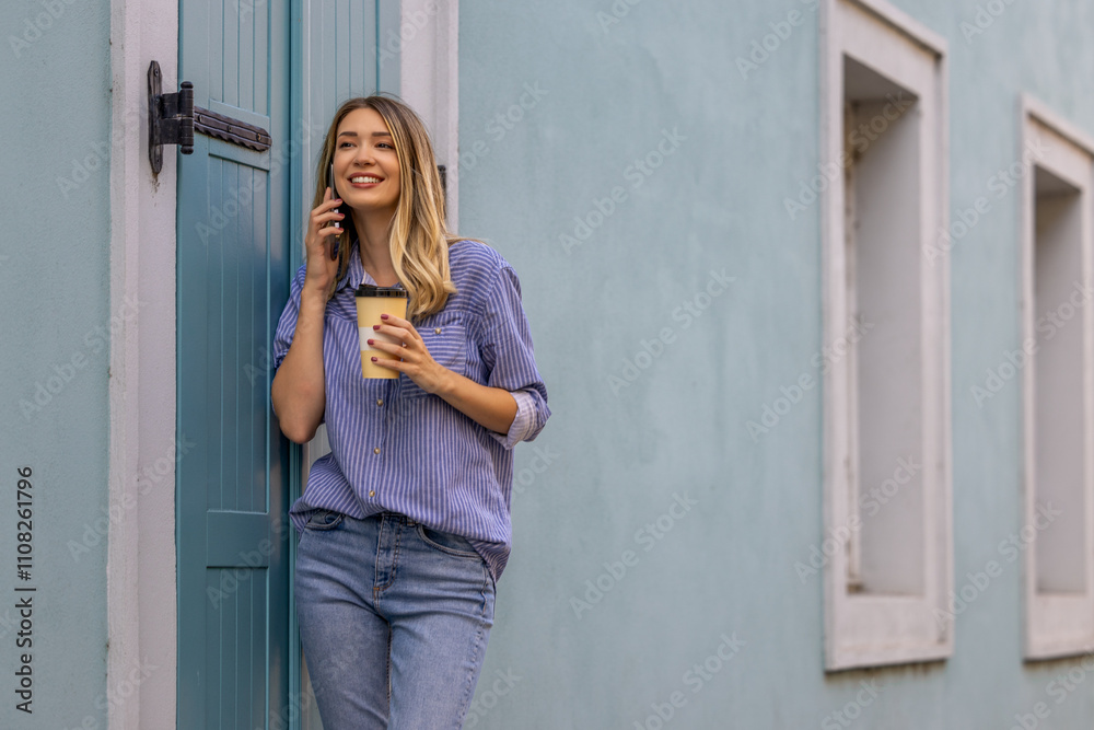 Fototapeta premium Young Woman Smiling While Talking on Phone with Coffee