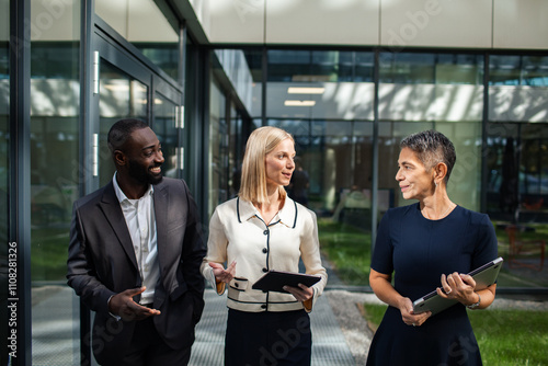 Business professionals discussing project outside office building