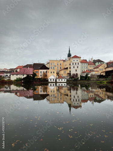 Charming reflection of colorful traditional houses in Jindřichův Hradec, Czech Republic. A serene autumn scene capturing the quaint architecture and calm waters of this picturesque town