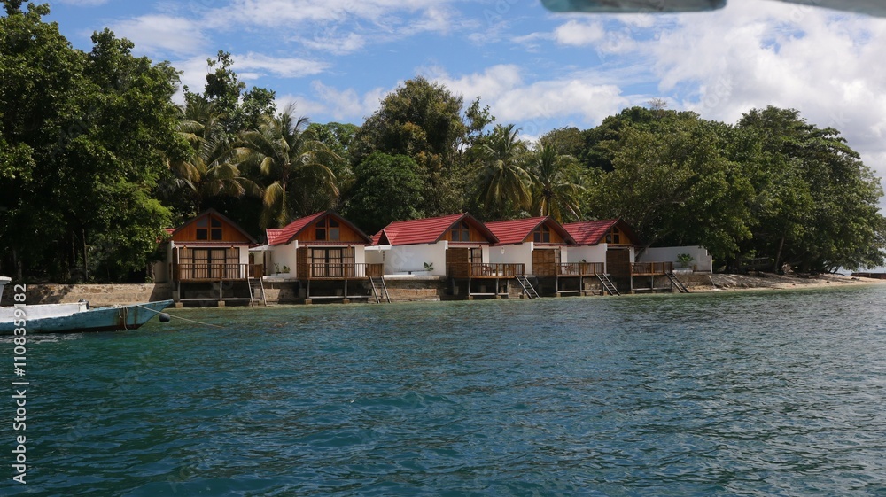 view from the shore of Dutungan Island, a tropical island in South Sulawesi, Indonesia. Trees with green leaves view from the shore of Dutungan Island, a tropical island in South Sulawesi, Indonesia. Trees with green leaves