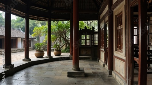 Tranquil courtyard of traditional Asian house with pillars, potted plants, and stone flooring.