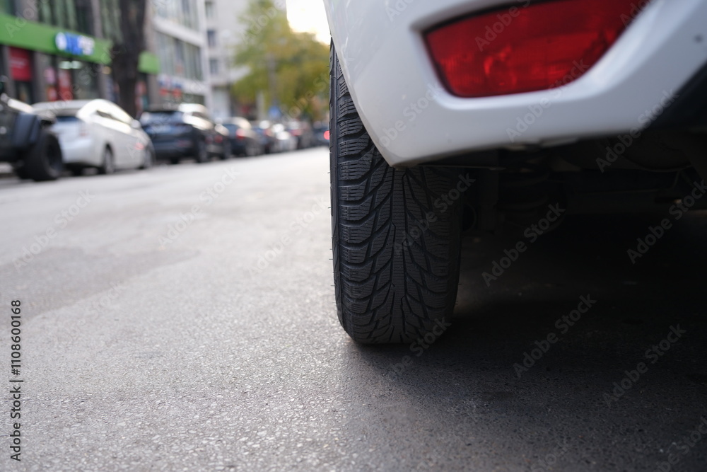 Fototapeta premium A closeup of a car tire on a busy city street, showcasing the essence of urban life and transportation