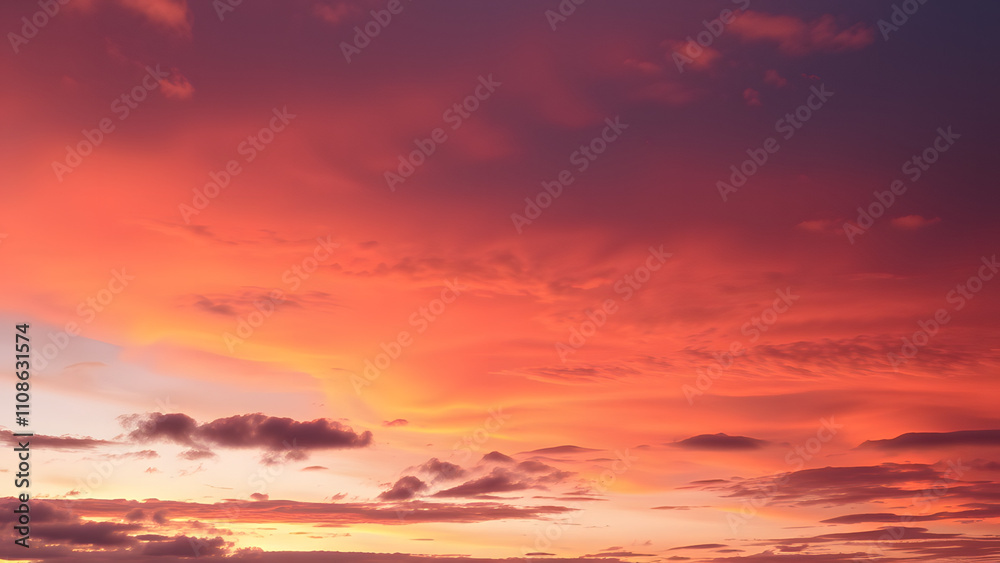 Fototapeta premium A serene dusk sky featuring layers of orange and deep purple with scattered cloud textures 