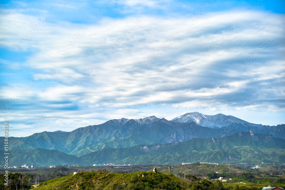 Fototapeta premium A mountain range with a cloudy sky in the background