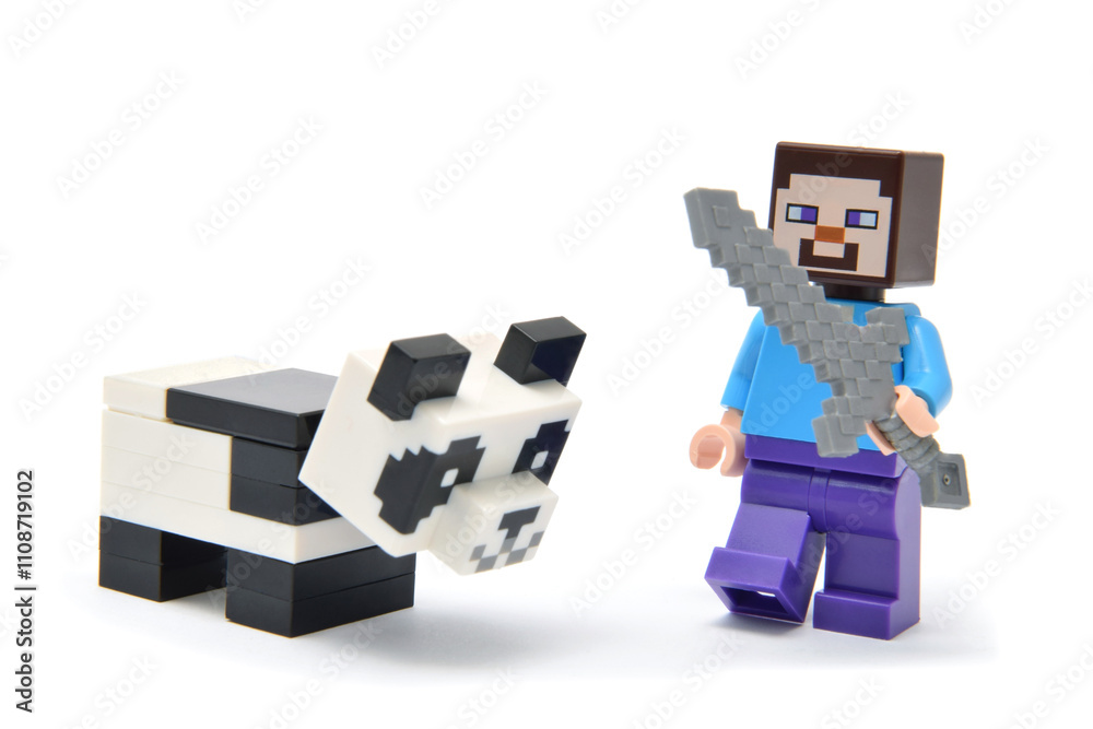 Fototapeta premium Lego minifigure of character from popular video game Minecraft with panda isolated on white. Editorial illustrative image of popular plastic toys.