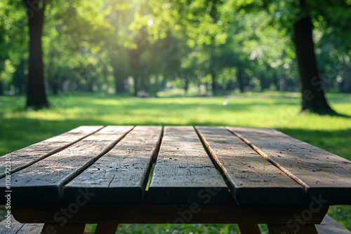 Sunlight shines on a wooden picnic table in a tranquil park setting surrounded by trees