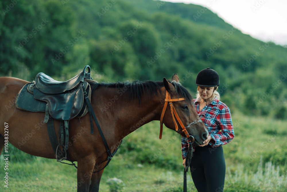 Obraz premium Happy blonde with horse in forest. Woman and a horse walking through the field during the day. Dressed in a plaid shirt and black leggings.