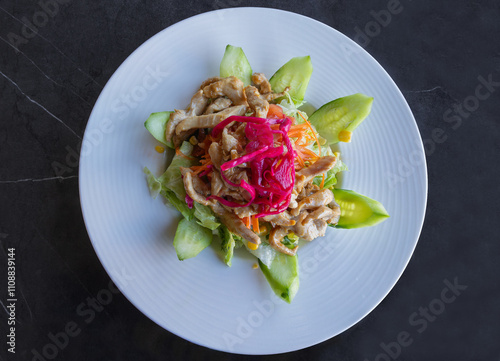 Obraz na płótnie Delicious summer salad prepared with red beet, chicken, cucumber, lettuce, corn, and dill, in a white plate, top view. w salonie