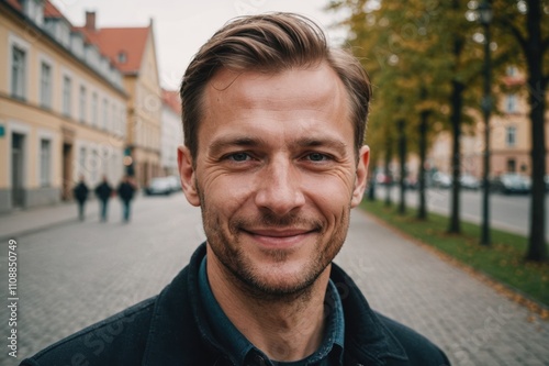 Close portrait of a smiling 40s Latvian man looking at the camera, Latvian city outdoors  blurred background photo