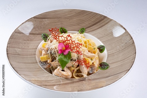 Pasta with Pieces of Meat in Creamy Sauce, Parmesan, and Garnish on a White Plate