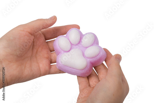 Pink toy cat paw in the hand isolated on a white background. Decompression squeeze toy. photo