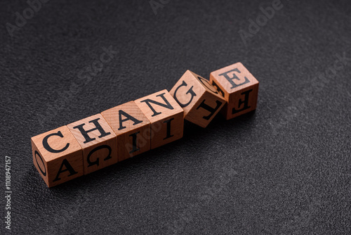 The inscription chance or change with wooden cubes on a dark concrete background